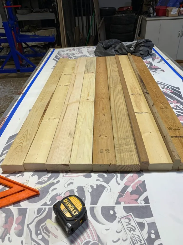 The pieces of wood all cut to a single length, sitting on a work bench