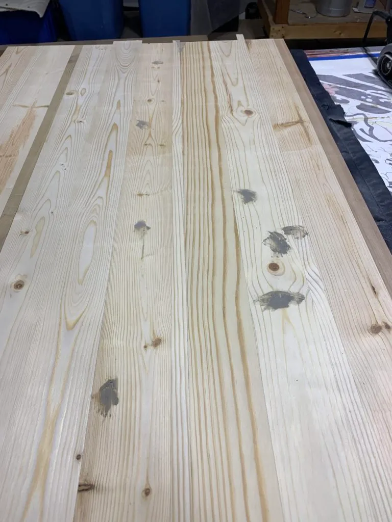 various spots with wood filler on the large plank of wood
