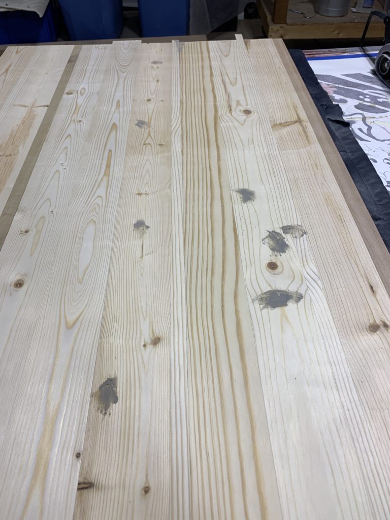 various spots with wood filler on the large plank of wood